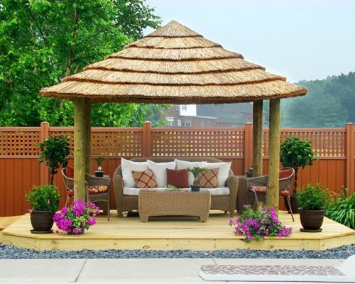 pergola with a solid roof, this one is covered in thatch, will 