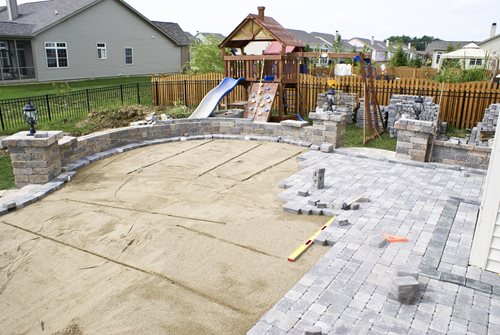  of patio construction in which pavers are being set in bedding sand